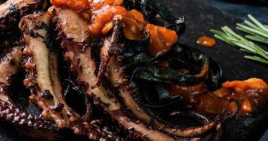 Pulpo a la plancha sobre pasta negra y tomate frito con ajo